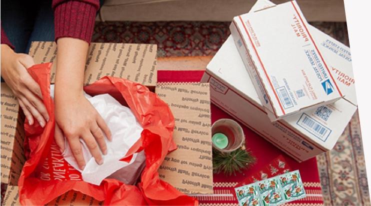 Young woman preparing holiday gifts and Priority Mail boxes to ship for December 25 delivery.